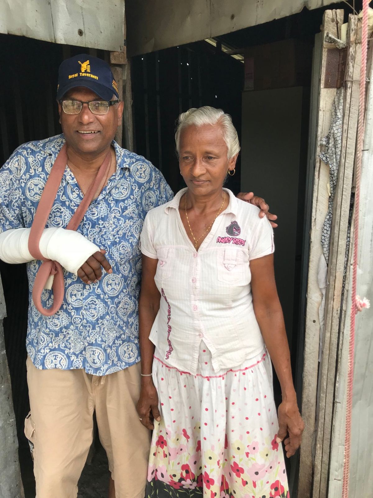 The project's founder next to a resident at the door of her hut