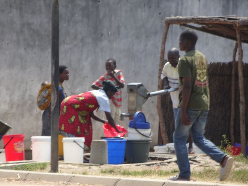 Mensen vullen emmers bij een handwaterpomp in Malawi